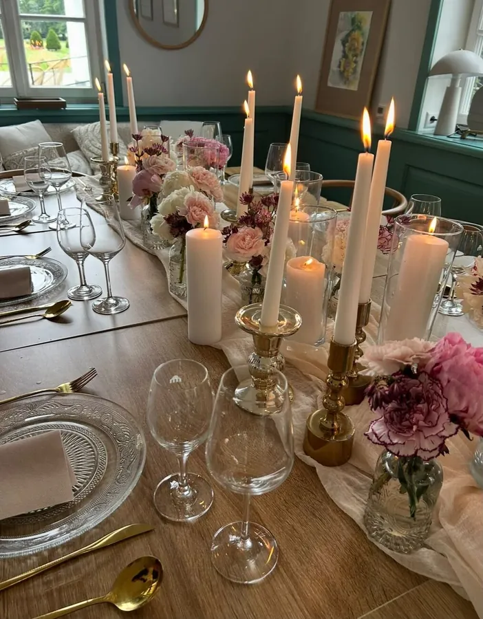 Festlich gedeckte Tafel mit Kerzen, Gläsern und Blumen im Schlossgarten Café